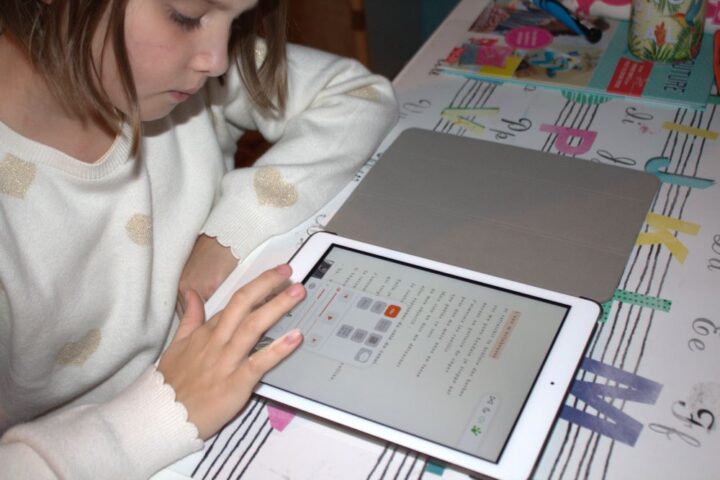 Une enfant utilisant la plateforme de lecture adaptée SONDO sur tablette